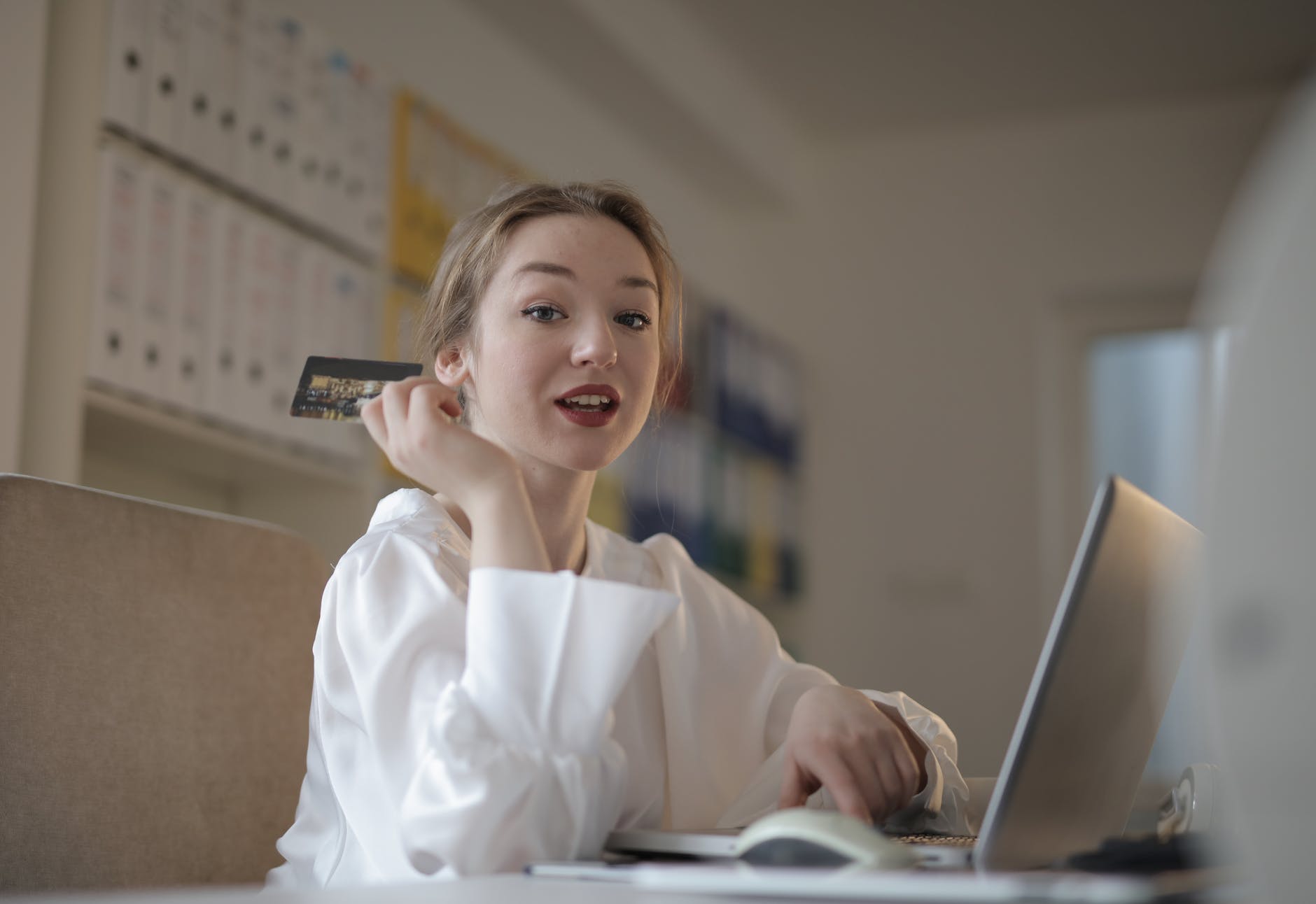 young woman with credit card paying online